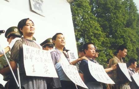 1-1-1-21-200111118228-17508506-4154-2547-1750850874 Vương Thực (bìa trái) cùng các đồng phạm trong băng nhóm bị áp giải ra trước công chúng. Ảnh: Sina