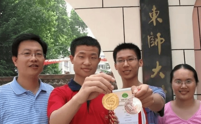 download-34-1749728716-4837-1749729119 Vi Đông Dịch (áo đỏ), khoe huy chương vàng Olympic Toán Quốc tế lần thứ 49 sau khi từ Tây Ban Nha về nước, trước cổng trường THPT Sư phạm Sơn Đông, hồi tháng 8/2008. Ảnh: Qilu Evening News