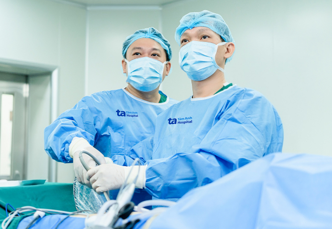 hi-nh-1-5-1-1750406065-1750406-1763-8771-1750412249 Bác sĩ Cương (phải) cùng BS.CKI Phạm Thế Anh phẫu thuật cắt khối u tuyến thượng thận cho chị Trang. Ảnh: Bệnh viện Đa khoa Tâm Anh