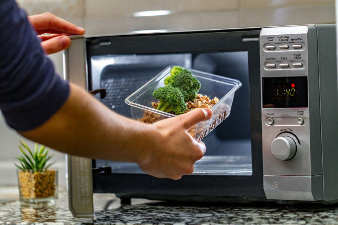 person-putting-food-into-micro-1240-2438-1750649745 Một người đang chuẩn bị hâm lại đồ ăn trong lò vi sóng. Ảnh: Chemical Safety Facts