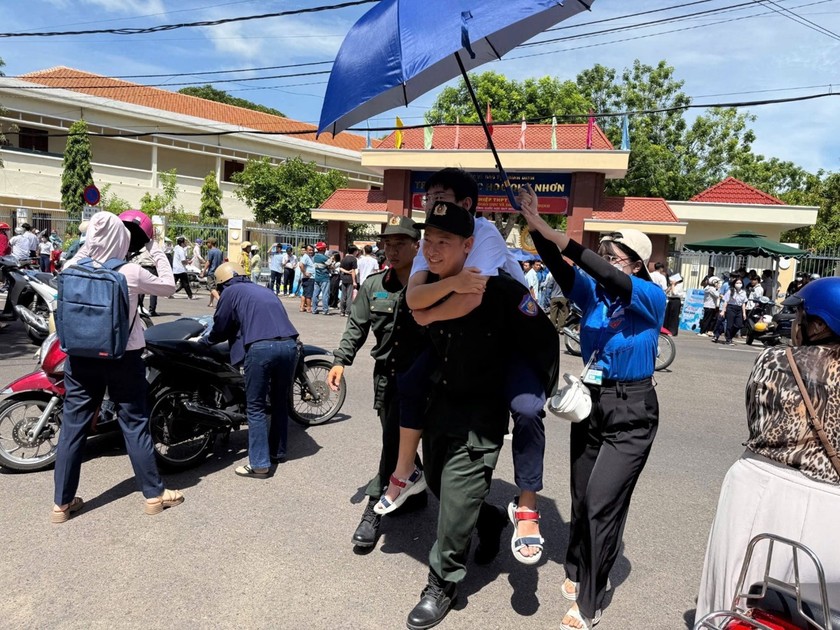 Các sĩ quan cảnh sát thuộc Trung đoàn Cảnh sát Cơ động Nam Trung Bộ hỗ trợ thí sinh Đ.V.P, người bị chấn thương ở chân, bằng cách giúp em vào phòng thi tại Trường Quốc học Quy Nhơn để đảm bảo em có thể làm bài thi của mình.