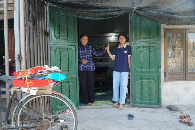 hoang-mi-va-me-truoc-nha-17520-3039-9306-1752035539 Hoàng Mi trước nhà căn 20 m2, bên phải là chiếc xe mẹ đi mua ve chai. Ảnh: Phạm Linh