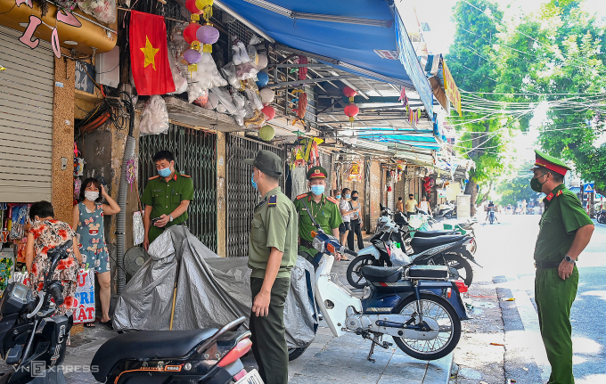huy-8615-1752486489-7613-1752487160 Công an phường tại Hà Nội nhắc nhở các cửa hàng trong thời gian giãn cách dịch Covid-19. Ảnh: Giang Huy