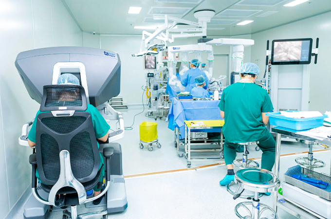th1-1751642963-9596-1751643118-6945-7741-1751673325 Tiến sĩ Hùng (trái) ngồi ở buồng điều khiển robot để phẫu thuật cho người bệnh. Ảnh: Bệnh viện Đa khoa Tâm Anh