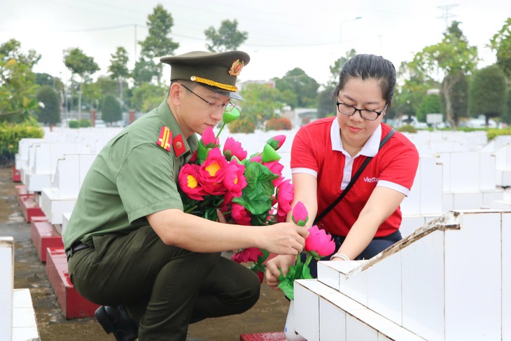 z6820439581274cfe23b078b26f8bddf144d141dfb4fa4-17529128657732054348087 Tuổi trẻ Công an An Giang dọn dẹp, thay hoa cho hơn 9.000 mộ liệt sĩ - Ảnh 1.
