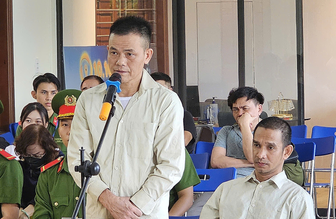 z6866311121350-961da2d2c243b1d-9530-5613-1754124842 Trần Kim Hoàn (đứng) và Trần Bảo Quốc (ngồi) tại tòa. Ảnh: Ngọc Hoa